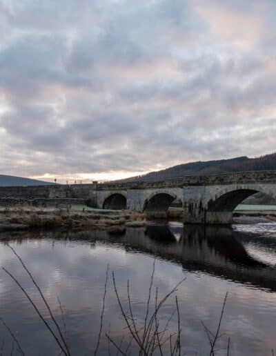 reflection of a bridge on body of water